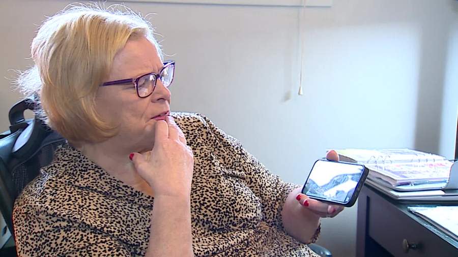 Ann Phillips Browning watches a video showing the funeral of Father Jacob Vellian, who she says sexually abused her as a teen in the 1970s. (Nov. 16, 2023)