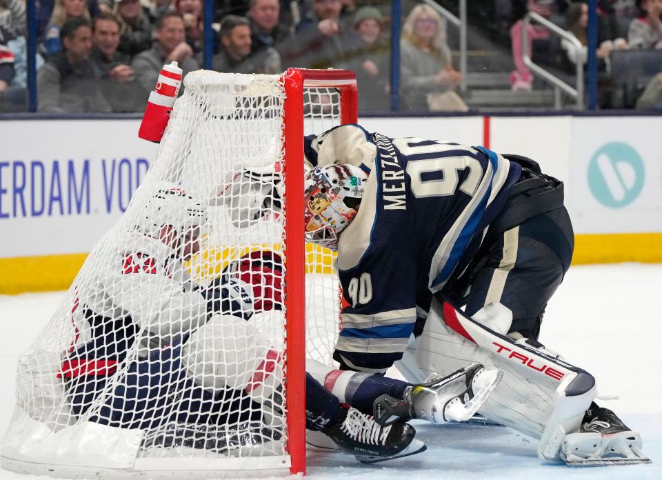 Dec. 201, 2023; Columbus, Ohio, USA; 
Washington Capitals right wing Tom Wilson (43) is tackled inside the goal by Columbus Blue Jackets goaltender Elvis Merzlikins (90) during overtime at Nationwide Arena on Thursday.