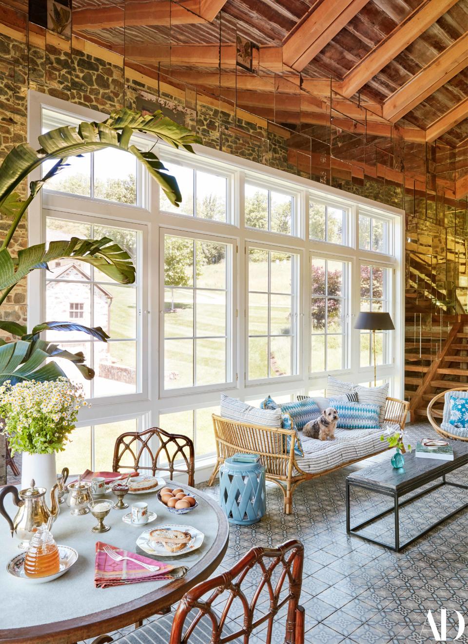 In the sunroom, the dining chairs, bamboo seating, and floor tiles are family heirlooms.