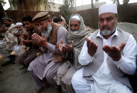 Relatives say prayers at the home of Sareer Ahmed, principal of the private Islamia College, who according to police was shot by a student accusing him of blasphemy in Charsadda, Pakistan January 23, 2017. REUTERS/ Fayaz Aziz