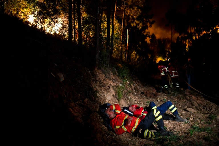 Firefighters rest during a wildfire at Penela, Coimbra, central Portugal, on June 18, 2017