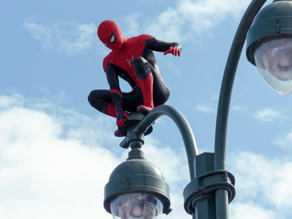 Tom Holland perched on a lamp post as Spider-Man in "Spider-Man: No Way Home."