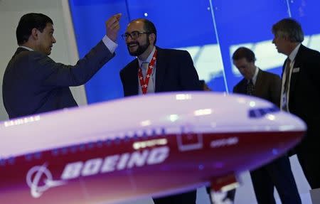 Visitors talk next to a Boeing 777X aircraft model at the Singapore Airshow February 13, 2014. REUTERS/Edgar Su