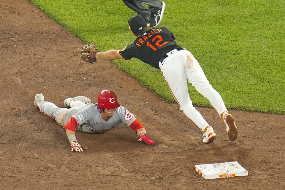 Cincinnati Reds' TJ Friedl, left, steals second base as Baltimore Orioles second baseman Adam Frazier (12) reaches for an errant throw in the sixth inning of a baseball game, Wednesday, June 28, 2023, in Baltimore. (AP Photo/Julio Cortez)