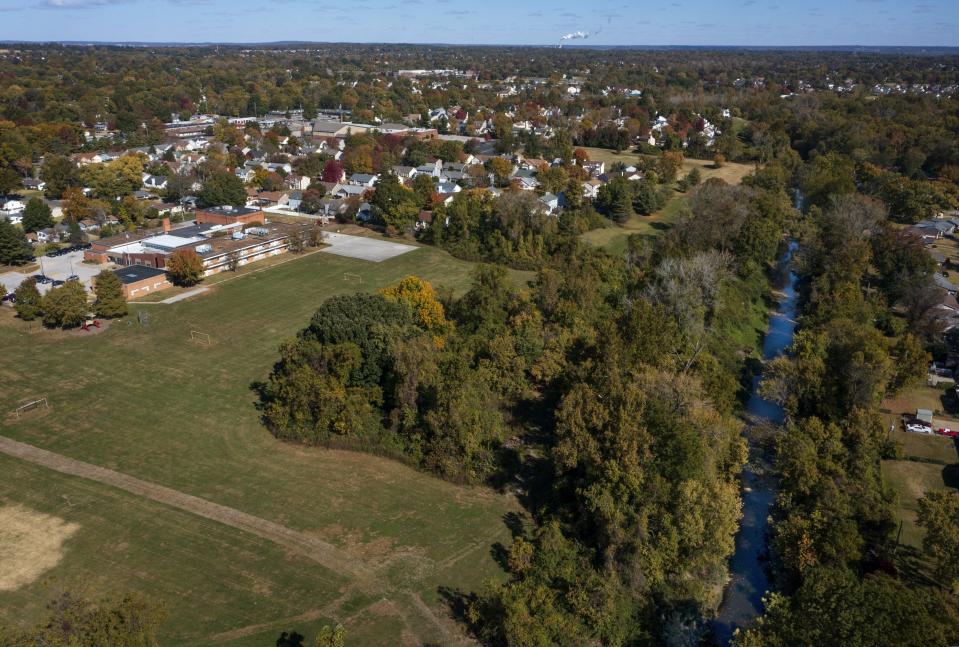 Jana Elementary School, left, which is in the Hazelwood School District, is seen on Monday, Oct. 17, 2022 in Florissant, Mo. Elevated levels of radioactive waste were found at the school, according to a recent report, and the parent-teacher association wants an open public meeting to discuss it. Coldwater Creek, right, which is prone to flooding, was contaminated by waste from nuclear bombs manufactured during World War II. Photo by David Carson, dcarson@post-dispatch.com/St. Louis Post-Dispatch via AP)/St. Louis Post-Dispatch via AP)