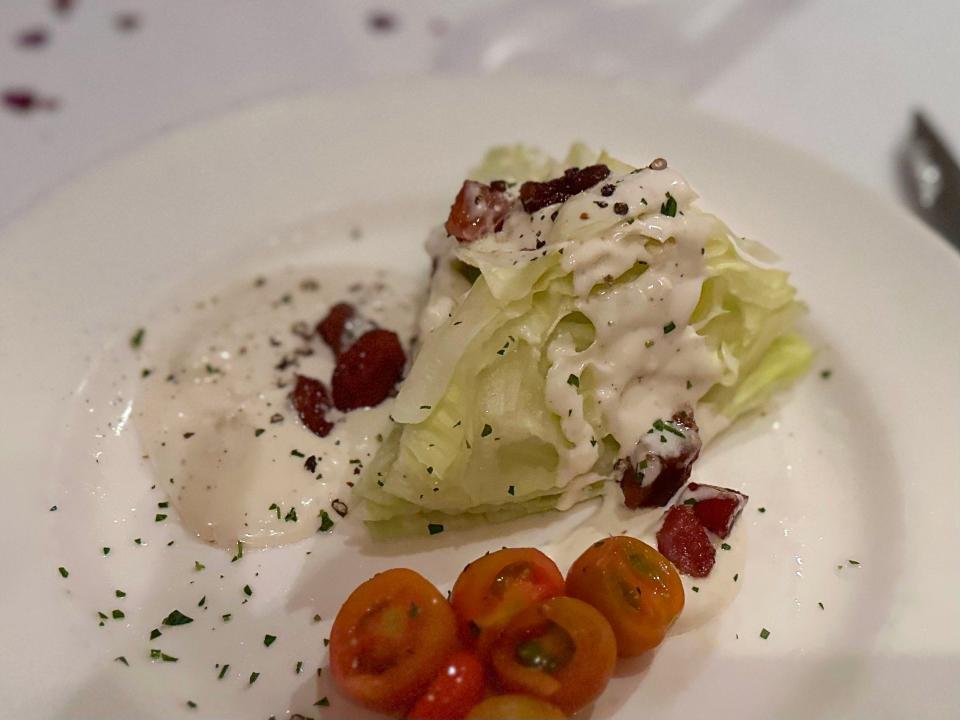 Lettuce, dressing, and tomatoes on a plate at Capital Grille 