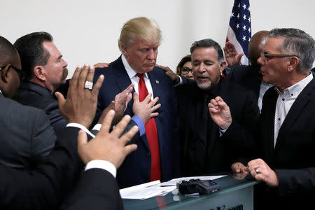 Republican presidential nominee Donald Trump prays with pastors during a campaign visit to the International Church of Las Vegas and the International Christian Academy in Las Vegas, Nevada, U.S., October 5, 2016. REUTERS/Mike Segar