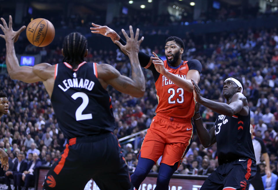 TORONTO, ON - NOVEMBER 12:  Anthony Davis #23 of the New Orleans Pelicans passes the ball as Kawhi Leonard #2 and Pascal Siakam #43 of the Toronto Raptors defend during the first half of an NBA game at Scotiabank Arena on November 12, 2018 in Toronto, Canada.  NOTE TO USER: User expressly acknowledges and agrees that, by downloading and or using this photograph, User is consenting to the terms and conditions of the Getty Images License Agreement.  (Photo by Vaughn Ridley/Getty Images)