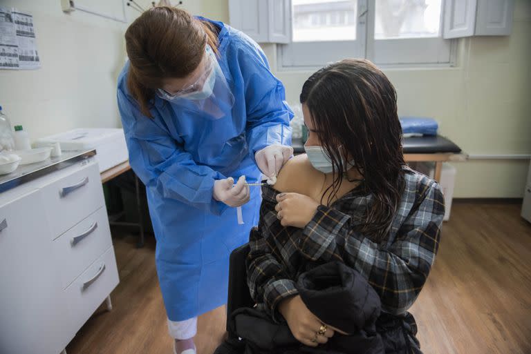 Una enfermera le aplica una inyección de la vacuna Pfizer contra COVID-19 a una joven en Montevideo. (AP Foto/Matilde Campodónico)