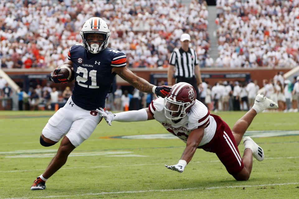 Auburn running back Brian Battie (21) gets around Massachusetts linebacker Jalen Stewart (23) as he carries the ball during the first half of an NCAA college football game Saturday, Sept. 2, 2023, in Auburn, Ala. (AP Photo/Butch Dill)