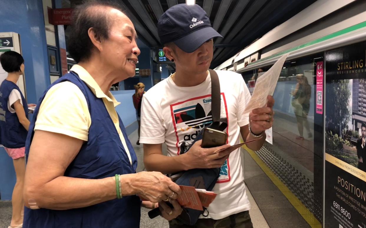 <span>Long-time fellow Queenstown RC member and COP volunteer </span>Lucy<span> Toh, 80, speaking to a commuter at Queenstown MRT Station on 17 August, 2018. (PHOTO: Wong Casandra/Yahoo News Singapore)</span>