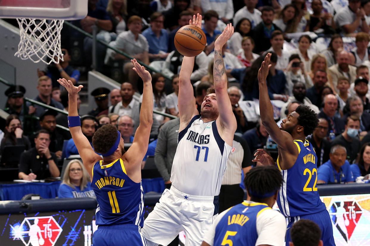 Luka Doncic of the Dallas Mavericks shoots the ball against Klay Thompson (11) and Andrew Wiggins (22) of the Golden State Warriors. (Photo by Tom Pennington/Getty Images)