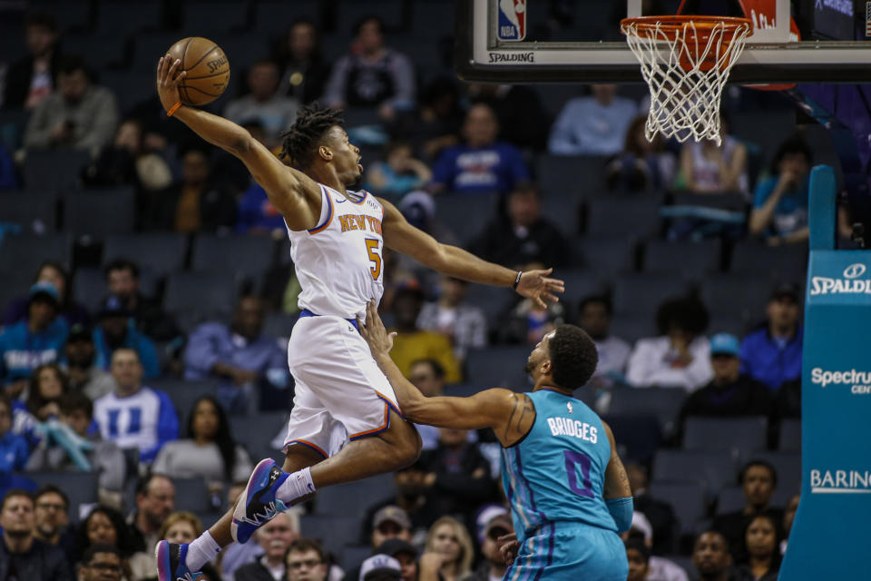 New York Knicks guard Dennis Smith Jr. drives for a dunk over Charlotte Hornets forward Miles Bridges during the first half of an NBA basketball game in Charlotte, N.C., Wednesday, Feb. 26, 2020. (AP Photo/Nell Redmond)