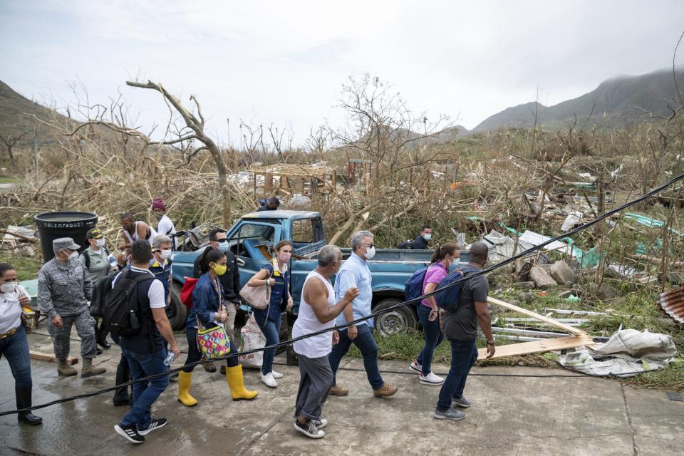 In this photo released by the Presidency of Colombia, President Ivan Duque, third from right, tours Providencia Island after the passing of Hurricane Iota, in Colombia, Tuesday, Nov. 17, 2020. Iota moved over the Colombian archipelago of San Andres, Providencia and Santa Catalina, off Nicaragua's coast, as a Category 5 hurricane. (Nicolas Galeano, Colombia Presidential Press Office via AP)