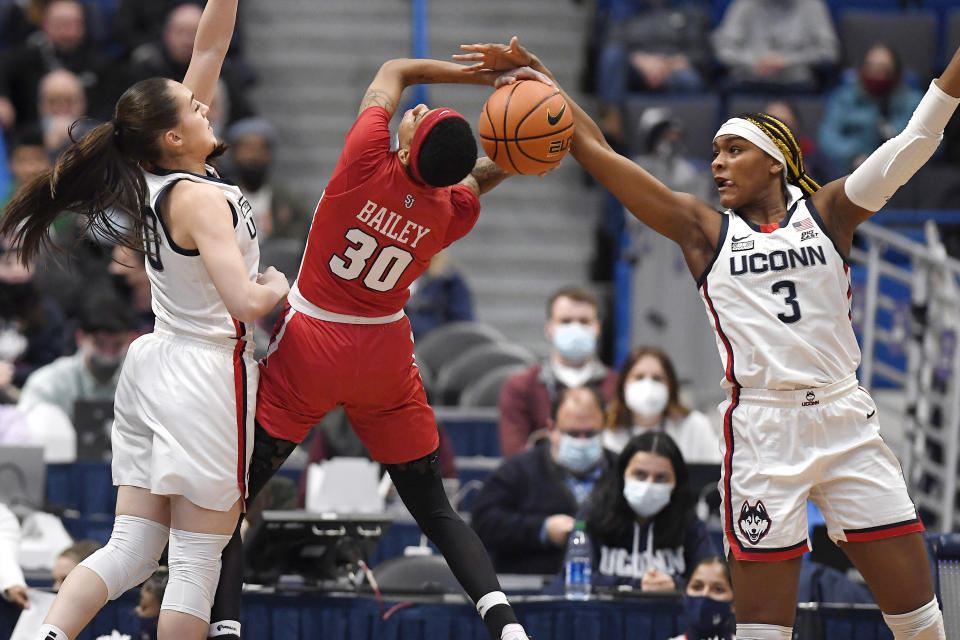 Connecticut's Aaliyah Edwards (3) blocks a shot by St. John's Kadaja Bailey (30) as Connecticut's Nika Mühl (10) defends in the first half of an NCAA college basketball game, Friday, Feb. 25, 2022, in Hartford, Conn. (AP Photo/Jessica Hill)