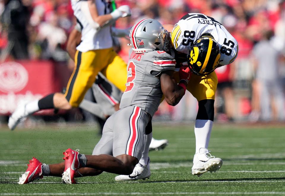 Oct 5, 2024; Columbus, OH, USA; Ohio State Buckeyes safety Caleb Downs (2) tackles Iowa Hawkeyes tight end Luke Lachey (85) after a catch in the first quarter during the NCAA football game at Ohio Stadium.