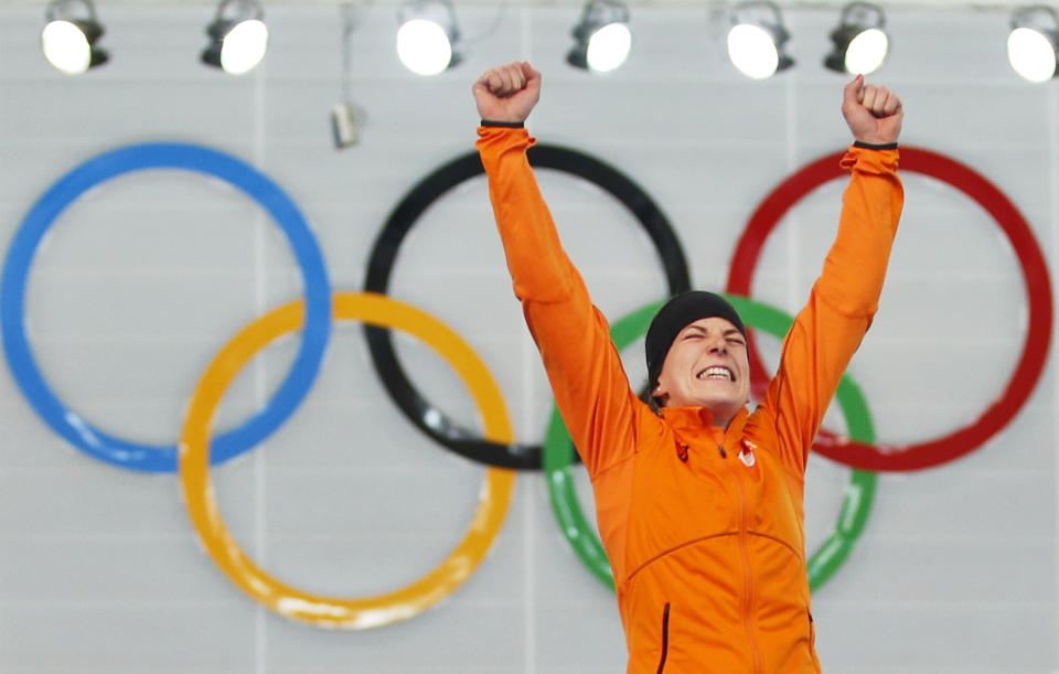 Ireen Wust of the Netherlands celebrates winning gold during the flower ceremony after winning gold in the women's 3,000-meter speedskating race at the Adler Arena Skating Center during the 2014 Winter Olympics, Sunday, Feb. 9, 2014, in Sochi, Russia. (AP Photo/Pavel Golovkin)