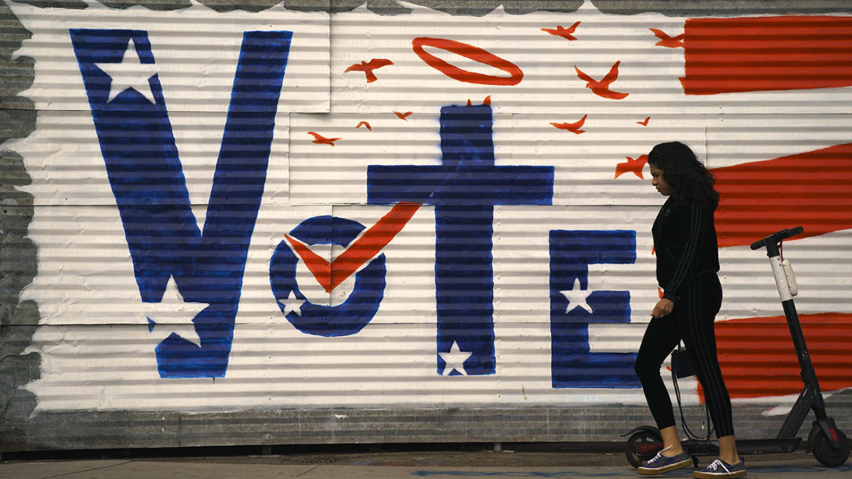 A woman walks past a voting sign painted on a wall Monday, Nov. 2, 2020, in the Venice Beach section of Los Angeles. (Jae C. Hong/AP)