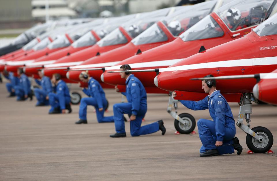 Ground staff kneel in front of The Royal Air Force aerobatic team, the Red Arrows, during The Royal International Air Tattoo at the RAF in Fairford