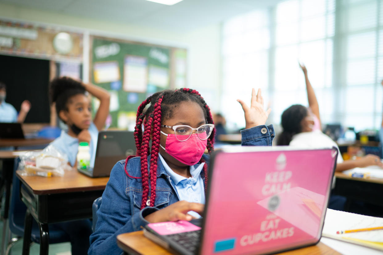 Capitol Heights Elementary School fourth grader Averie Timberlake raises her hand in a class that is also being attended by virtual students on Oct. 12, 2021. 