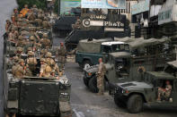 Lebanese army soldiers sit on their vehicles as they deployed to contain the tension after heavy fire in the coastal town of Khaldeh, south of Beirut, Lebanon, Sunday, Aug. 1, 2021. At least two people were killed on Sunday south of the Lebanese capital when gunmen opened fire at the funeral of a Hezbollah commander who was killed a day earlier, an official from the group said. (AP Photo/Bilal Hussein)