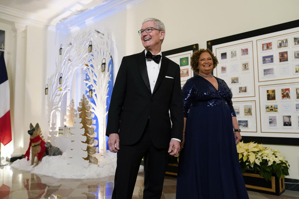 Apple CEO Tim Cook and Lisa Jackson, former administrator of the Environmental Protection Agency, arrive for the State Dinner with President Joe Biden and French President Emmanuel Macron at the White House in Washington, Thursday, Dec. 1, 2022. (AP Photo/Susan Walsh)
