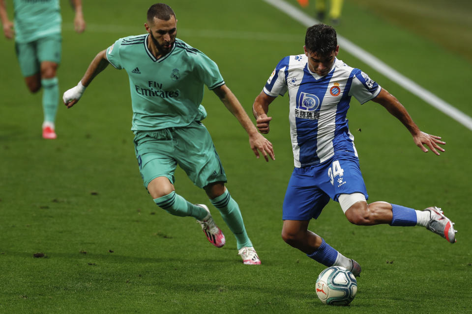 Espanyol's Victor Gomez, right, runs past Real Madrid's Karim Benzema during the Spanish La Liga soccer match between RCD Espanyol and Real Madrid at the Cornella-El Prat stadium in Barcelona, Spain, Sunday, June 28, 2020. (AP Photo/Joan Monfort)