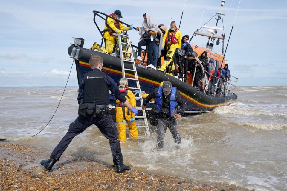 Immigration Enforcement officers and members of the RNLI assist a group of people thought to be migrants from an RNLI lifeboat after they were brought into Dungeness, Kent (Gareth Fuller/PA) (PA Wire)