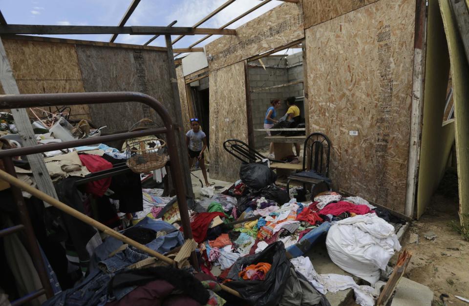 REFILE - CORRECTING DATE A family surveys the damage inside of their home in San Jose del Cabo, after Hurricane Odile hit Baja California, September 19, 2014. Mexico sent in troops and police to safeguard thousands of tourists stranded in the storm-battered Mexican Pacific resort of Los Cabos on Thursday after widespread looting. Odile churned into the southern tip of the Baja California peninsula on Sunday as a Category 3 hurricane, wreaking havoc on a scenic area popular with U.S. sun seekers that has rarely witnessed such devastation. REUTERS/Henry Romero (MEXICO - Tags: ENVIRONMENT SOCIETY TRAVEL)