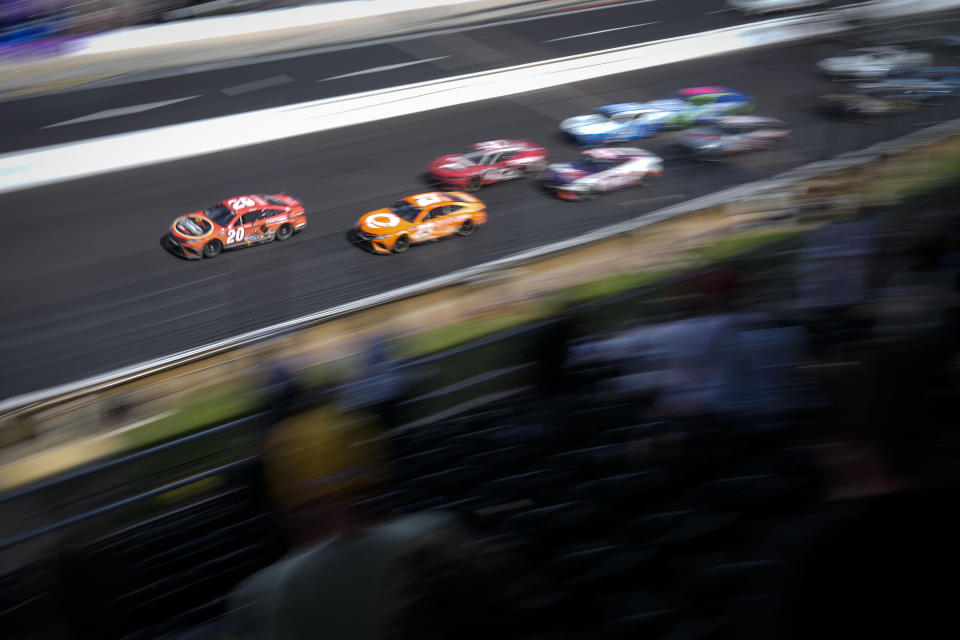 Christopher Bell (20) leads the field on a restart for the final segment during the running of a NASCAR Cup Series auto race at Indianapolis Motor Speedway, Sunday, July 31, 2022, in Indianapolis. (AP Photo/AJ Mast)
