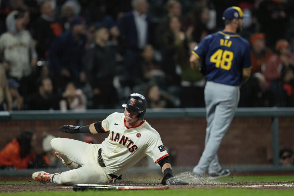 San Francisco Giants' Tyler Fitzgerald, left, scores on Mike Yastrzemski's double during the fourth inning of a baseball game against the Milwaukee Brewers, Wednesday, Sept. 11, 2024, in San Francisco. Yastrzemski was tagged out at third on the play. (AP Photo/Godofredo A. Vásquez)