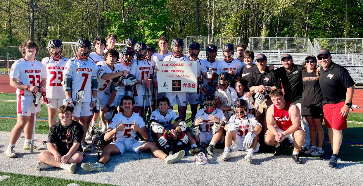 Mount Olive senior midfielder Adam DeCristofaro celebrates with teammates after breaking the school records for career goals and points against West Morris on May 2, 2024.