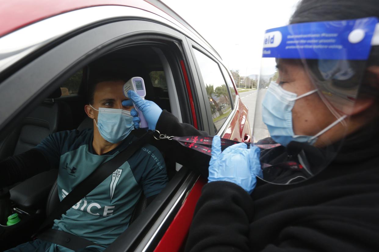 Diego Buonanotte of Universidad Catolica gets his temperature checked as he arrives for the first training during the coronavirus pandemic on July 16, 202,0 in Santiago, Chile. Teams of first and second division in areas on quarantine were allowed to train in groups following strict protocols.