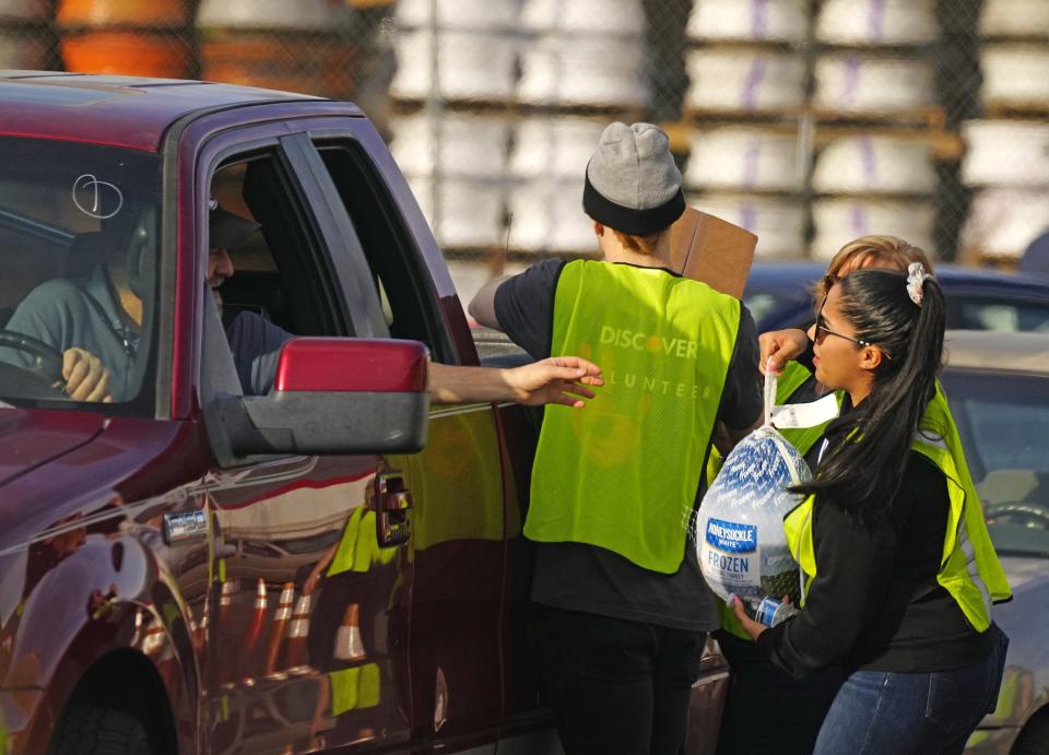 Volunteers load up trucks and truck beds with food and turkeys during an annual Thanksgiving food distribution at St. Mary's Food Bank on Nov. 22, 2022.