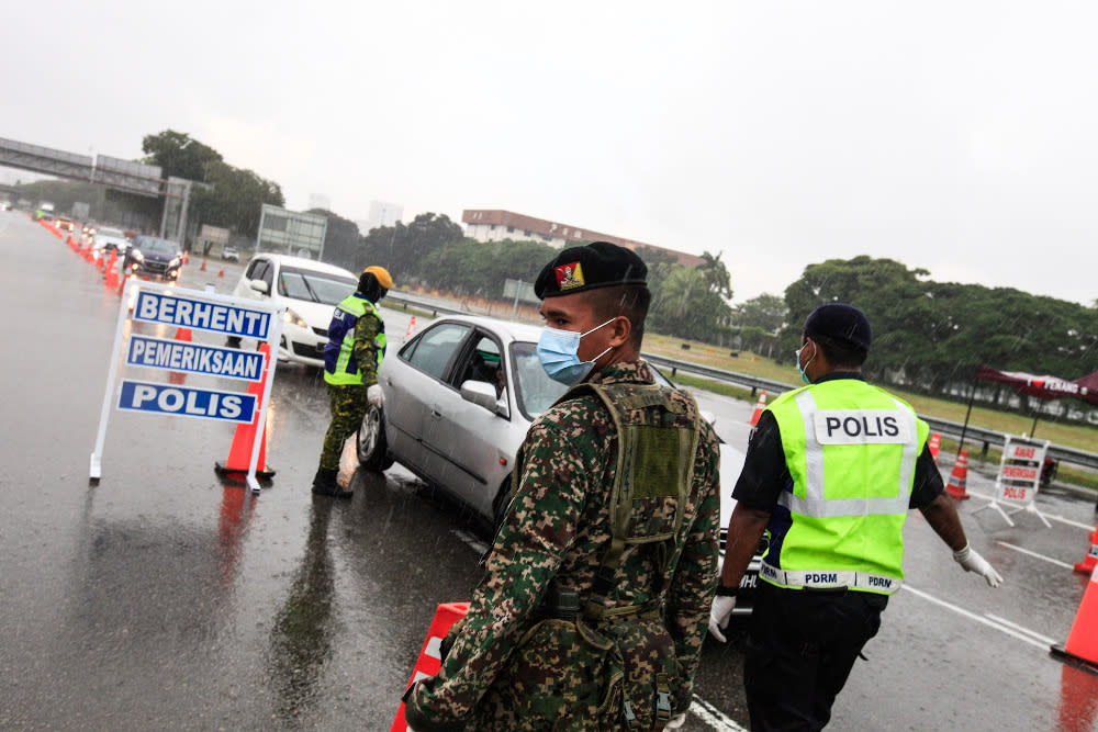 Policemen along with Army and RELA personnel join forces to man roadblocks near the Penang Bridge Toll Plaza April 3, 2020. — Picture by Sayuti Zainudin