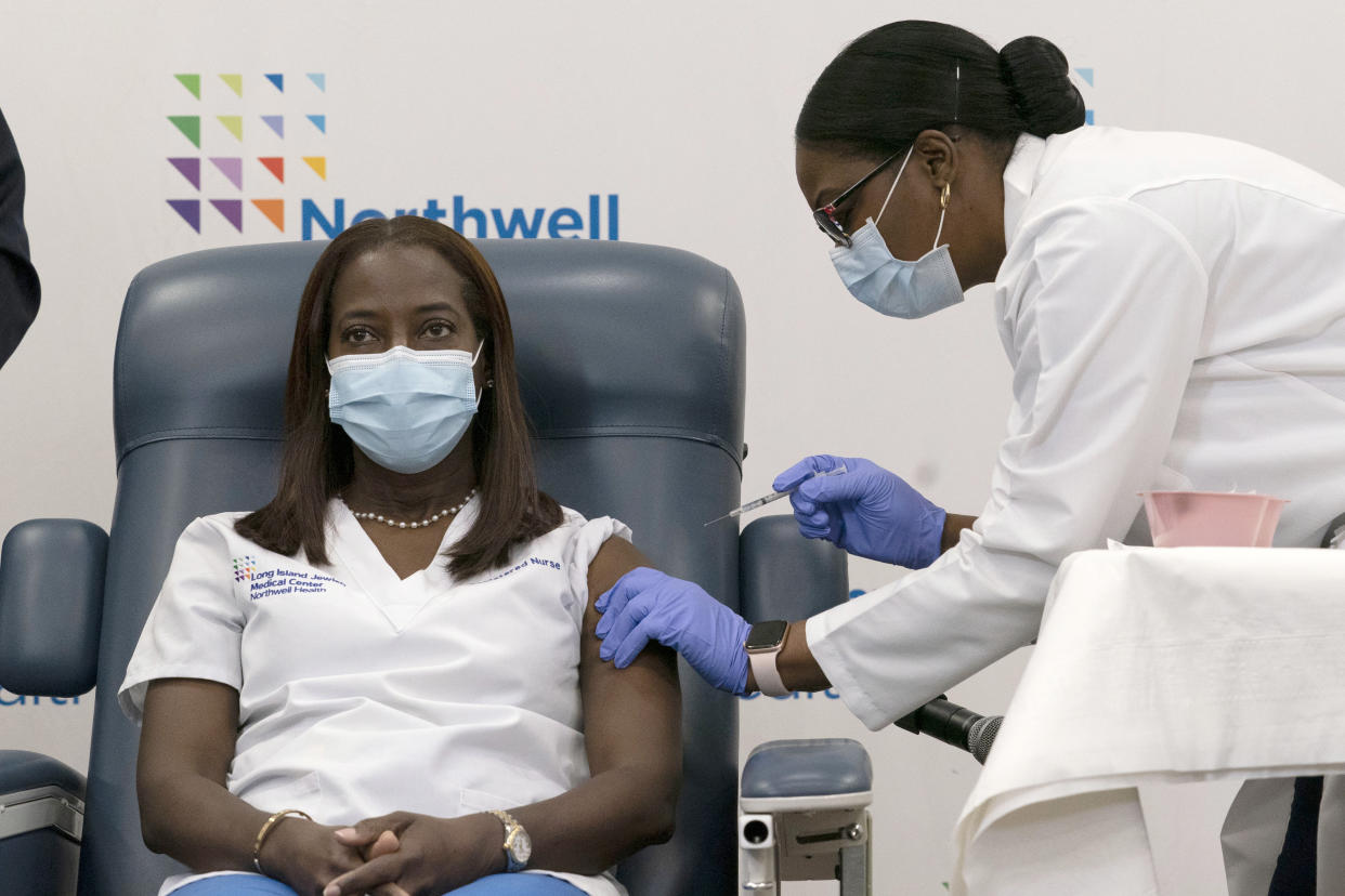 FILE - Sandra Lindsay, left, a nurse at Long Island Jewish Medical Center, is inoculated with the Pfizer-BioNTech COVID-19 vaccine by Dr. Michelle Chester, Monday, Dec. 14, 2020, in the Queens borough of New York. Lindsay has appeared on panels, Zoom town halls and at other events in the United States and in Jamaica, her homeland, promoting vaccination and addressing questions, fears and misconceptions from the public. (AP Photo/Mark Lennihan, Pool, File)