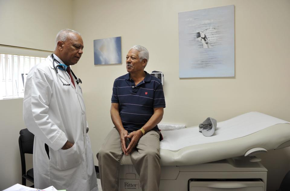 Dr. Sixto Caro, left, speaks with patient Jose Rodriguez at the Medspan Associates clinic on Oct. 3, 2012, in New York City in a Dominican neighborhood in Brooklyn.