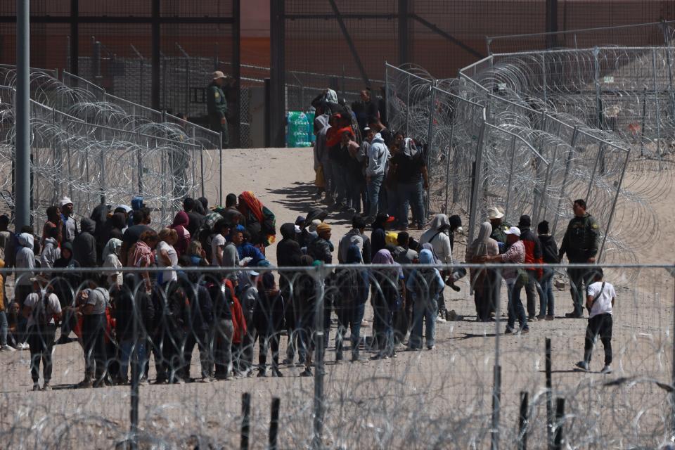 Migrants who crossed the Rio Grande at Gate 40 are seeing sitting down on order from the Texas National Guard on April 18, 2026.