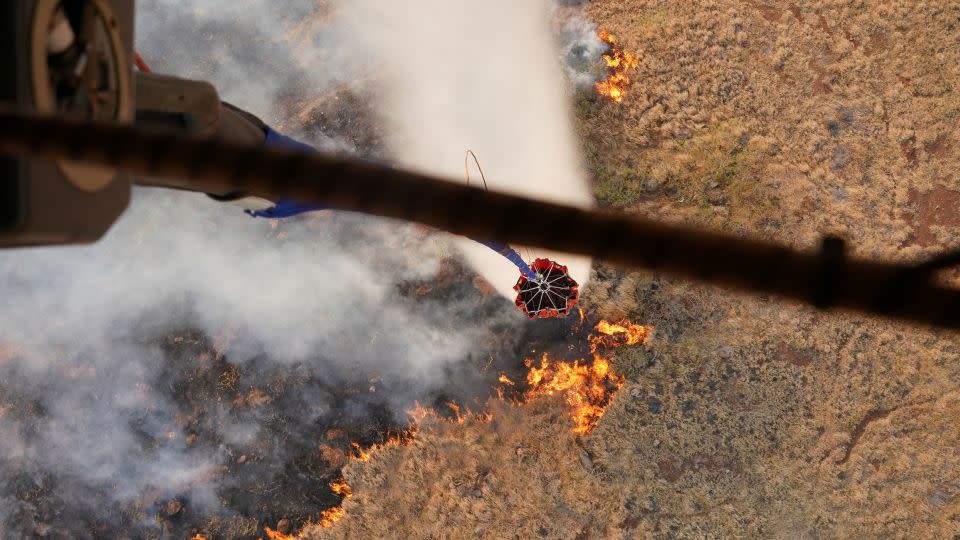 Hawaii Army National Guard CH47 Chinook helicopters perform aerial water bucket drops on the island of Maui to assist with fight of wildfires in Maui, Hawaii, August 9, 2023.  - Hawaii National Guard/Handout/Reuters