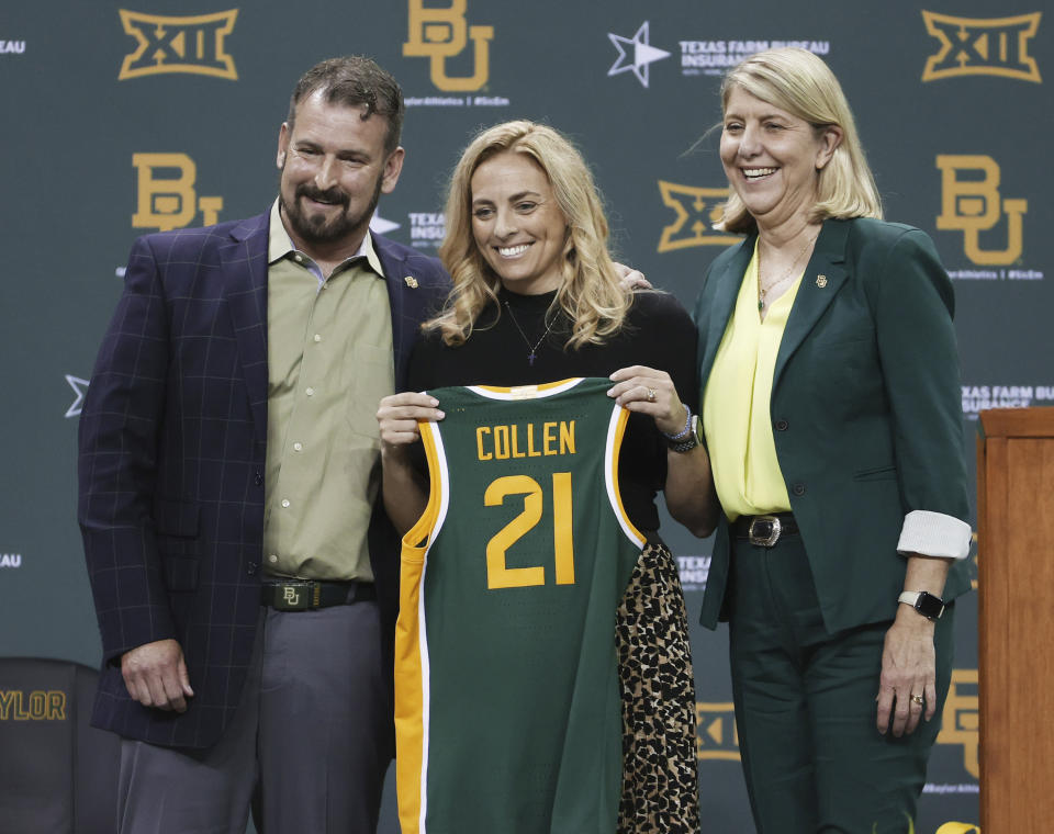 Nicki Collen, center, holds up a jersey while bring introduced as the new Baylor women's head basketball coach by school president Linda Livingstone, right, and athletic director Mack Rhoades, left, Wednesday, May 5, 2021, in Waco, Texas. (Rod Aydelotte/Waco Tribune-Herald via AP)
