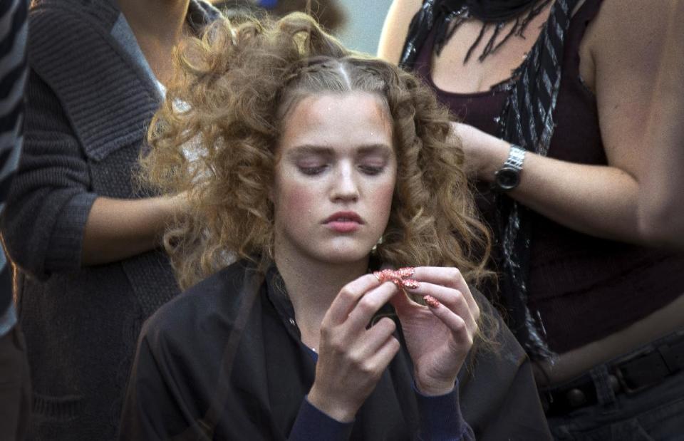 A model sits as preparations are made backstage ahead of the Spring/Summer 2013 Meadham Kirchoff collection at a central London venue, during London Fashion Week, Tuesday, Sept. 18, 2012. (AP Photo/Joel Ryan)