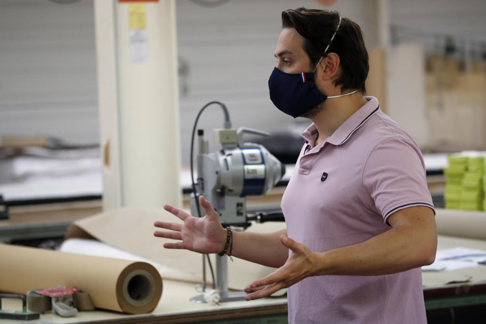 In this Friday, June 12, 2020 photo, director Thomas Delise gestures in Chanteclair Hosiery, a French knitwear clothing manufacturer in Saint Pouange, east of Paris. The French praised the altruism of luxury goods companies such as LVMH, Kering and Chanel for diverting their production facilities to make millions of face masks for the public during the peak of their country's coronavirus outbreak. Now, the companies that helped France avoid a dangerous shortage say they need help unloading a surplus of 20 million washable masks. (AP Photo/Francois Mori)