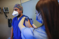 FILE - In this Oct. 9, 2020, file photo, a health worker, right, administers the first dose of a COVID-19 vaccine currently on phase III clinical trials to Cem Gun, an emergency medicine physician at the Acibadem Hospital in Istanbul. The World Bank has approved $12 billion in financing to help developing countries buy and distribute coronavirus vaccines, tests, and treatments, aiming to support the vaccination of up to 1 billion people, the bank said in a statement late Tuesday, Oct. 13. (AP Photo/Emrah Gurel, File)