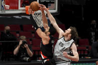 San Antonio Spurs center Jakob Poeltl, right, blocks the shot of Portland Trail Blazers center Enes Kanter, left, during the second half of an NBA basketball game in Portland, Ore., Monday, Jan. 18, 2021. (AP Photo/Steve Dykes)