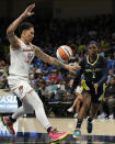 Phoenix Mercury center Brittney Griner defends as Dallas Wings' Odyssey Sims (2) passes the ball beneath the basket during the first half of a WNBA basketball game Wednesday, June 7, 2023, in Arlington, Texas. (AP Photo/Tony Gutierrez)