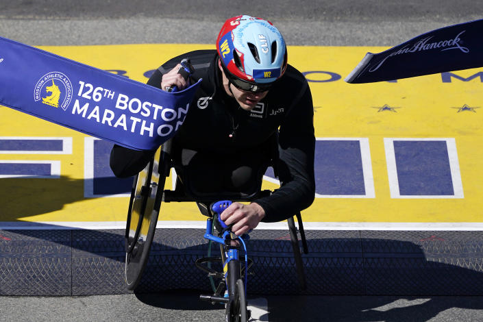 Daniel Romanchuk, of the United States, breaks the tape to win the men's wheelchair division of the Boston Marathon, Monday, April 18, 2022, in Boston. (AP Photo/Charles Krupa)
