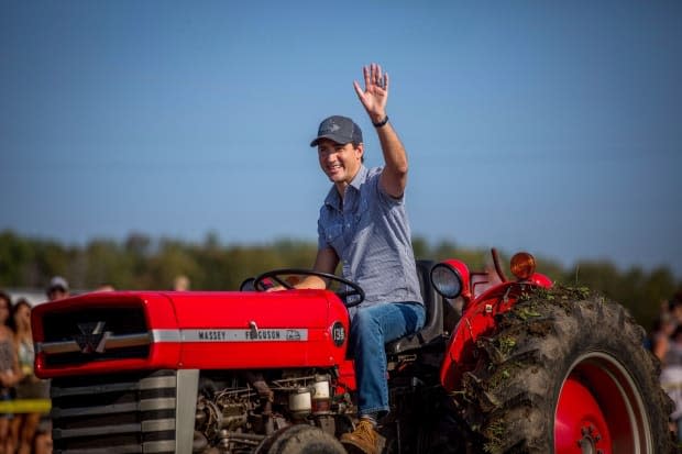 Justin Trudeau drives a tractor at the International Plowing Match and Rural Expo in Walton, Ont., on Friday, September 22, 2017. Research suggests a rural-urban split between Liberal and Conservative supporters has been deepening since the 1960s. (Chris Donovan/Canadian Press - image credit)