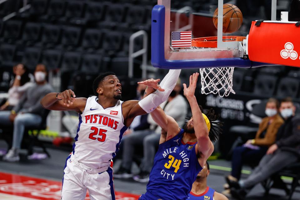 Detroit Pistons forward Tyler Cook is fouled by Denver Nuggets center JaVale McGee in the first half at Little Caesars Arena, May 14, 2021.