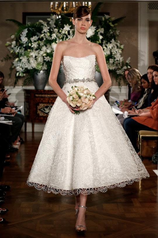 This photo released by Romona Keveza shows a sleeveless Romona Keveza Coutour wedding dress. The traditional bridal gown isn't a skimpy silhouette: It's long and typically without a plunging neckline or high slit. There's often a whole lot of fabric. One of the few opportunities for brides to be a little bare is to go with a strapless or sleeveless dress. New bridal collections are dominated by dresses with no sleeves. (AP Photo/Romona Keveza)