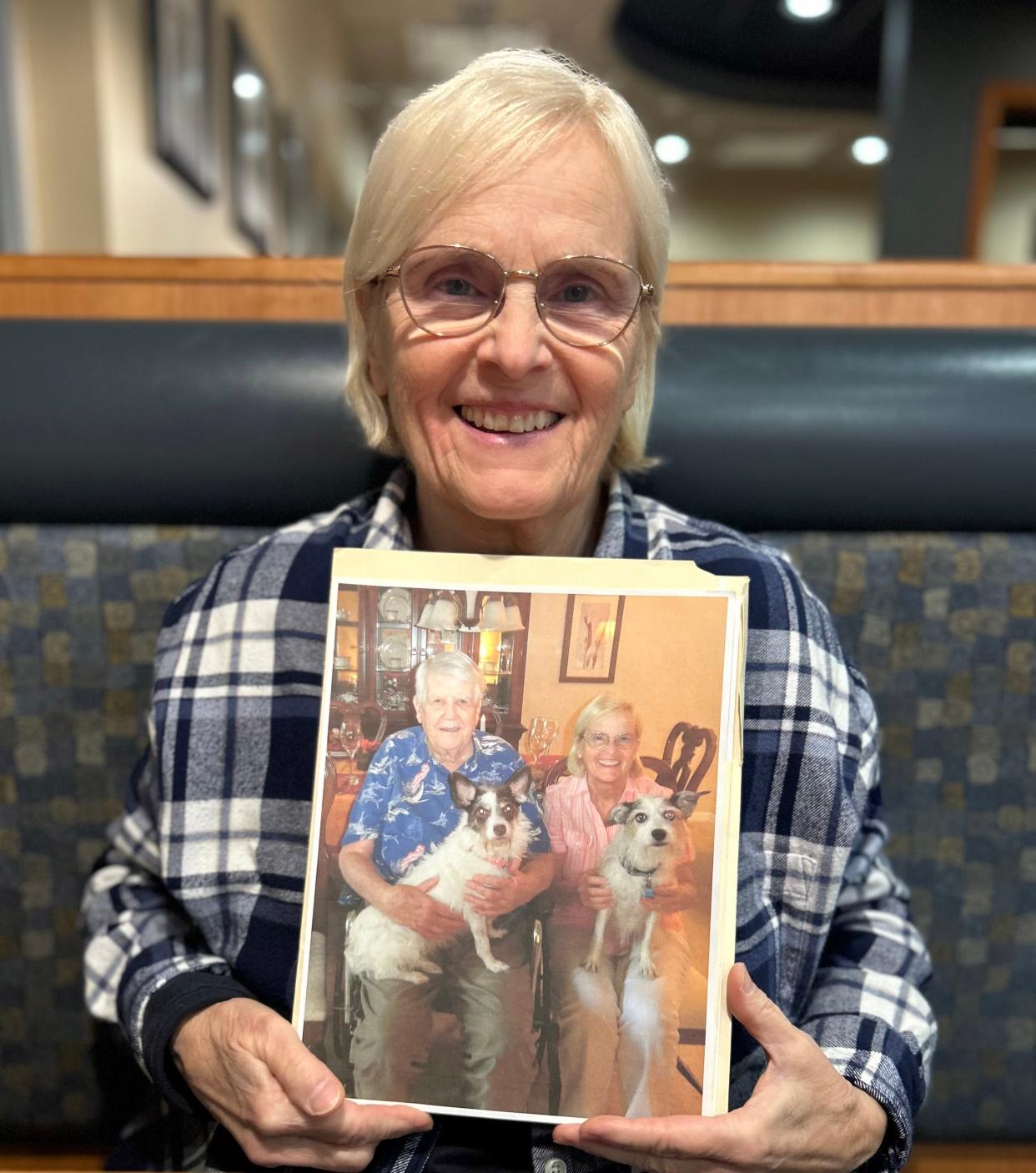 Maggie Kristjanson, a Sarasota teacher's aide, said two things got her through the immediate impact of the death of her husband, Ivan, more than three years ago: her dogs, and Season of Sharing. Shown is Maggie with an old photo of herself with her husband holding Joey, their Jack Russell Terrier. Maggie is holding Katie, who passed away before her husband and was replaced by Pixie, a Chihuahua-Jack Russell mix that she still has.